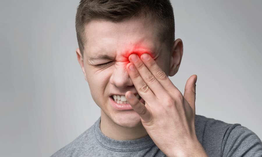 Person rubbing eye due to eye pain